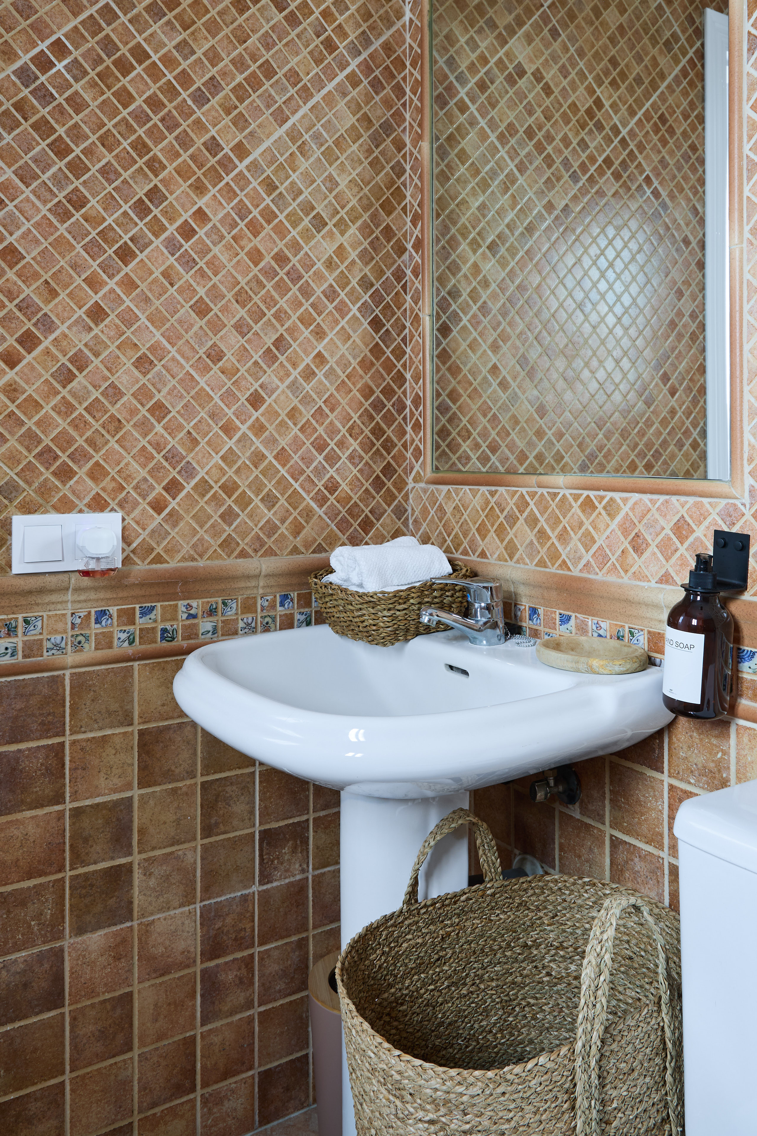Casa Wanda bathroom detail with warm tile and fresh flowers