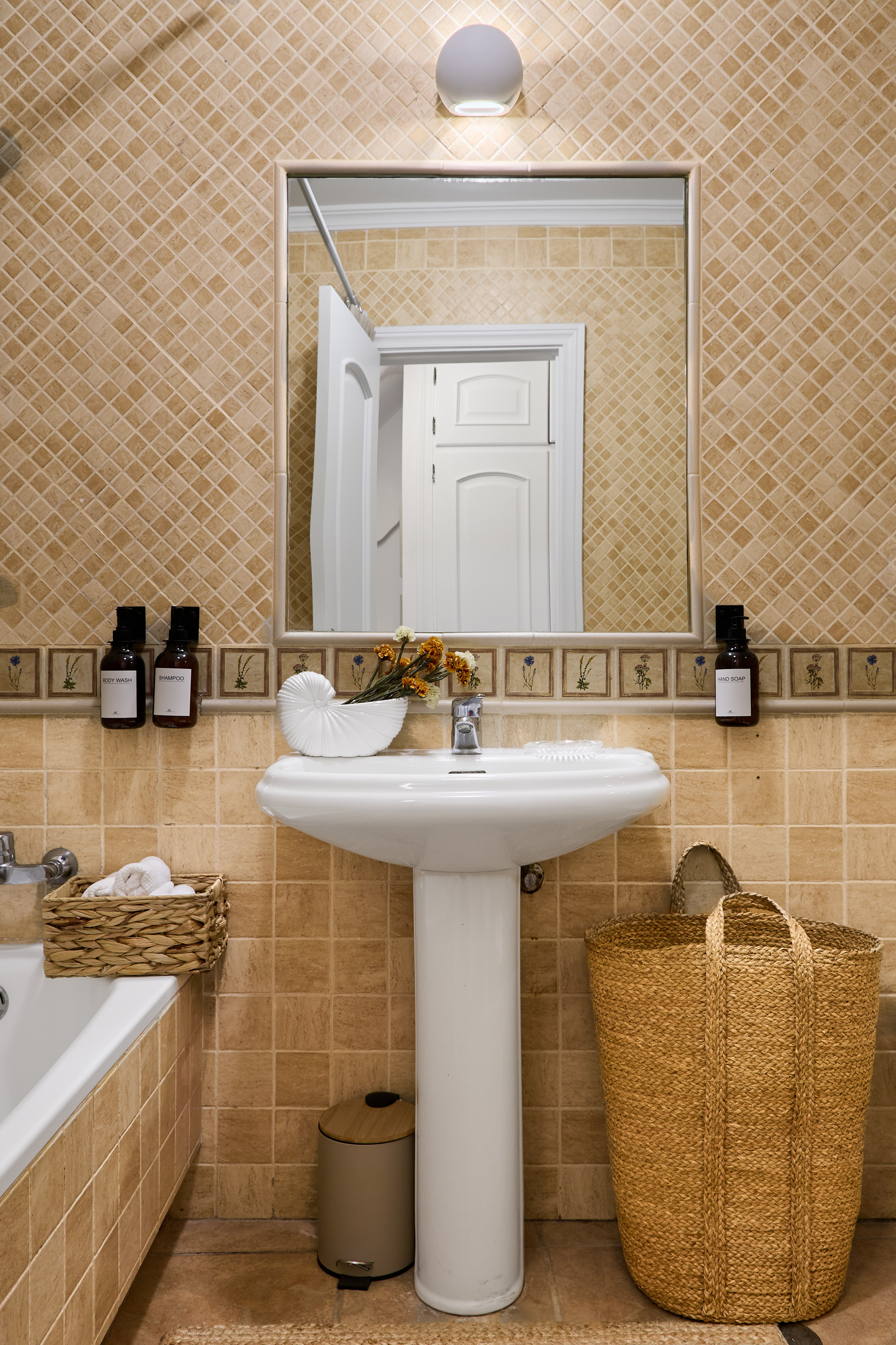 Casa Wanda bathroom detail with warm tile and fresh flowers