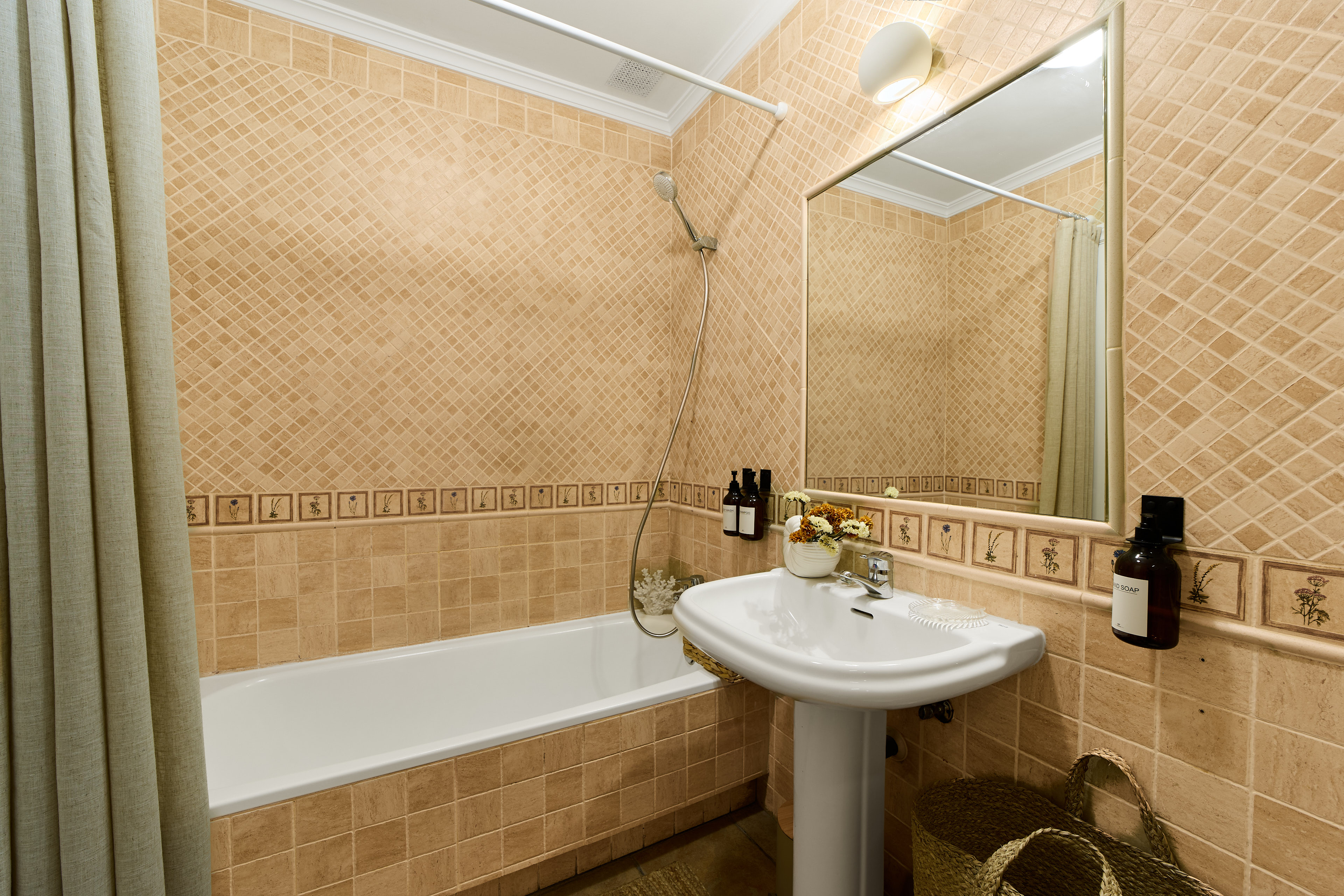Casa Wanda bathroom detail with warm tile and fresh flowers