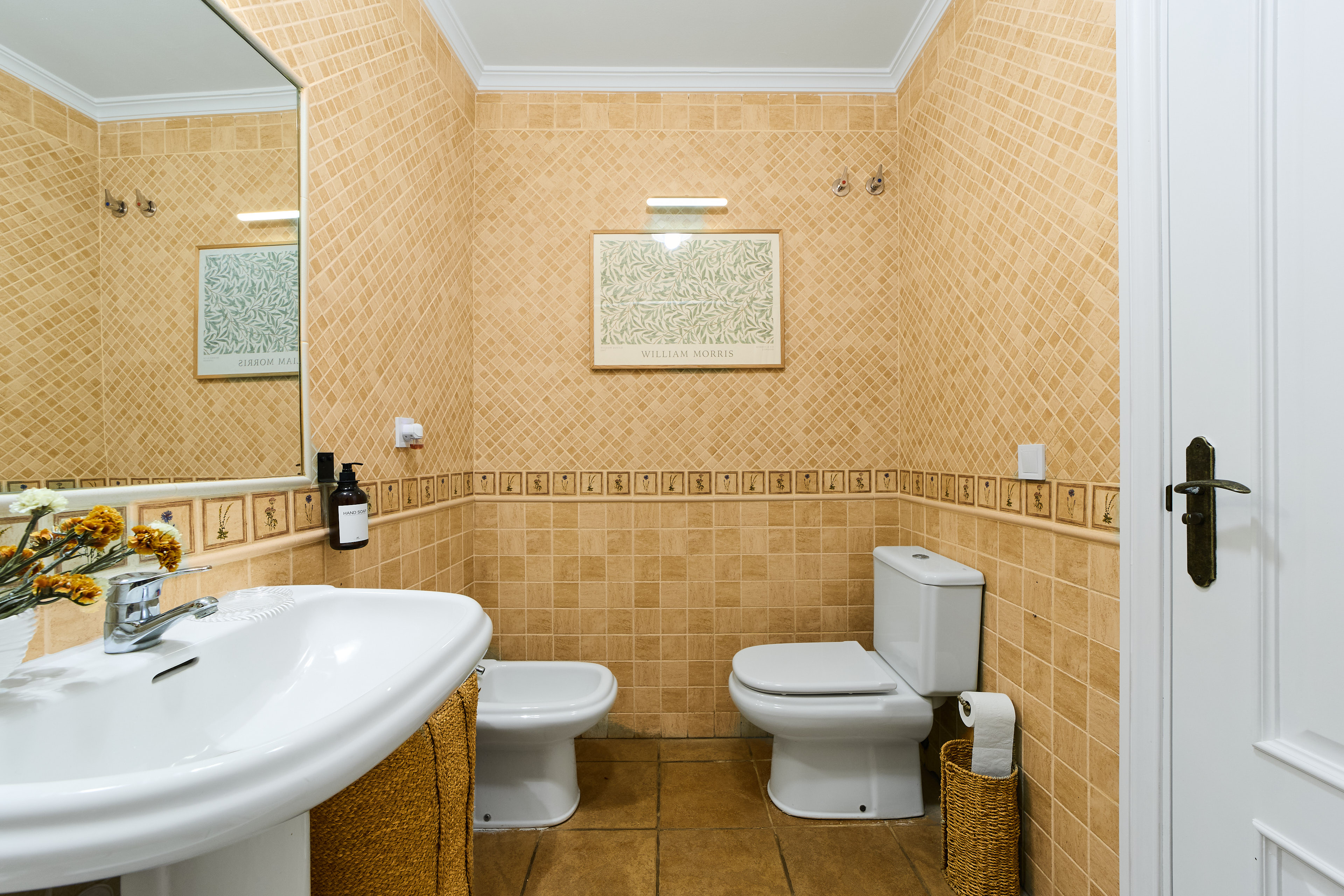 Casa Wanda bathroom detail with warm tile and fresh flowers