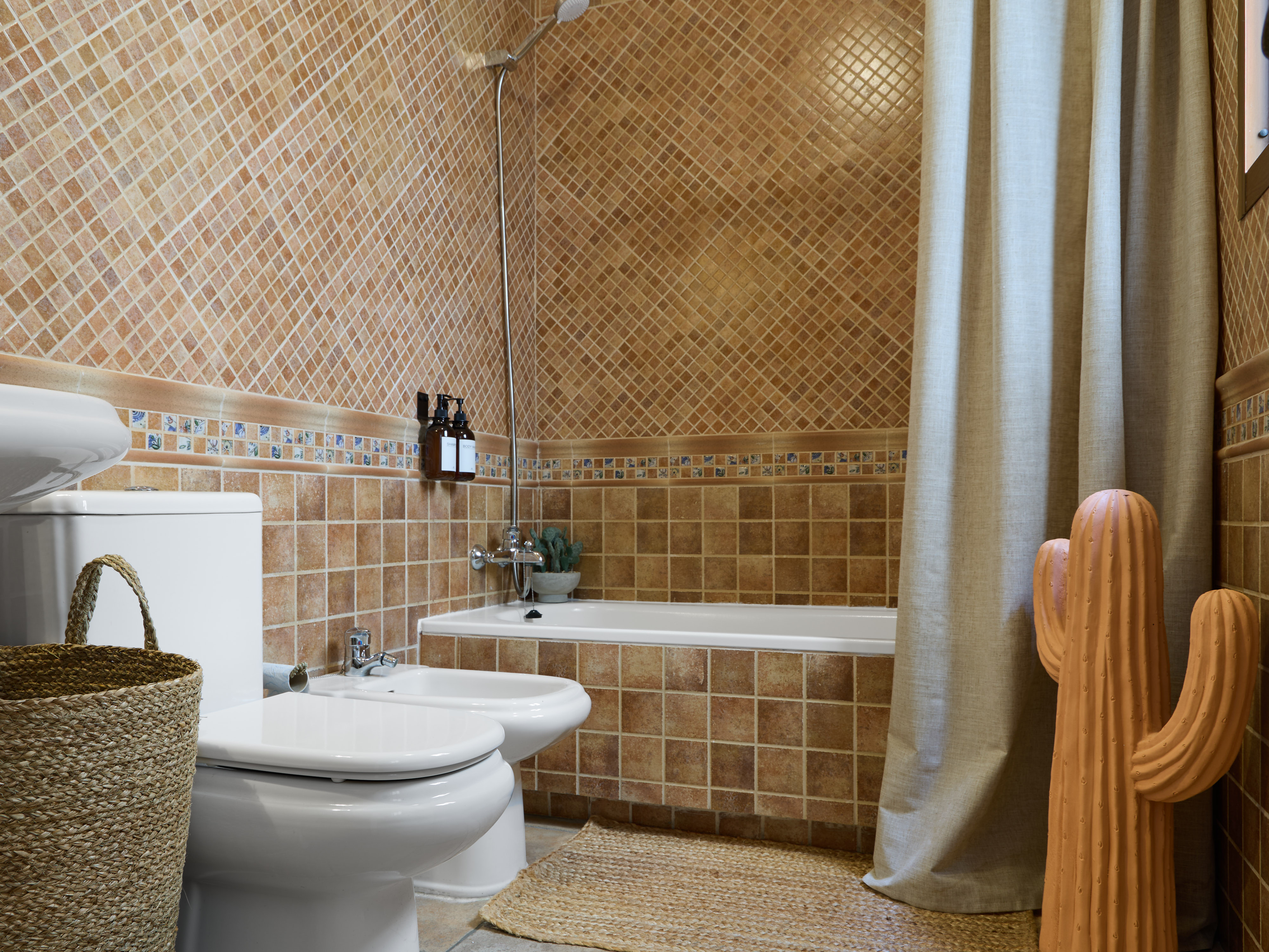 Casa Wanda bathroom detail with warm tile and fresh flowers